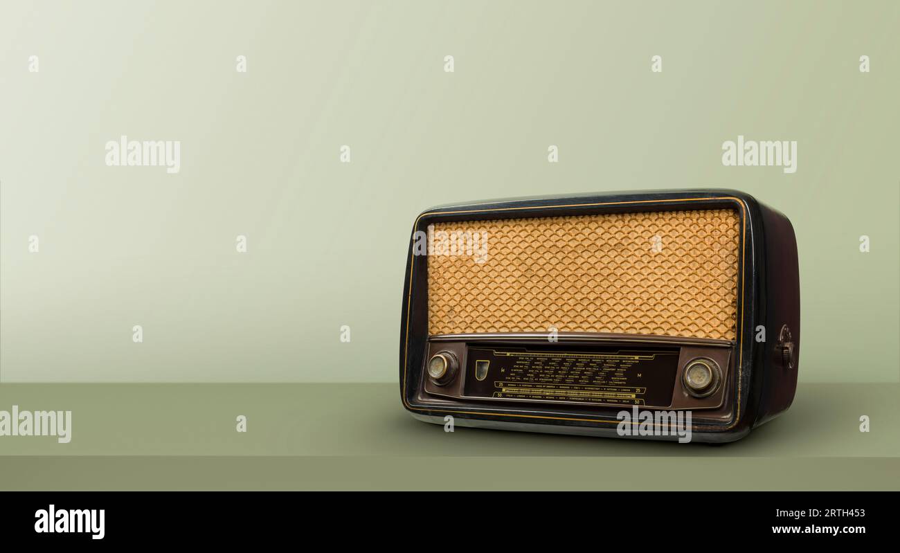 Antique radio on green table and vintage background. Stock Photo