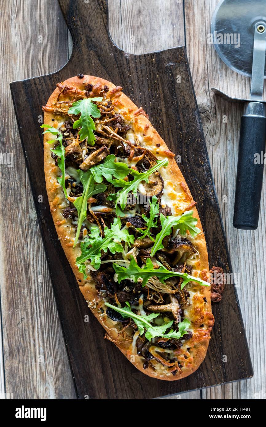 Top down view of a homemade mushroom beef flatbread pizza topped with