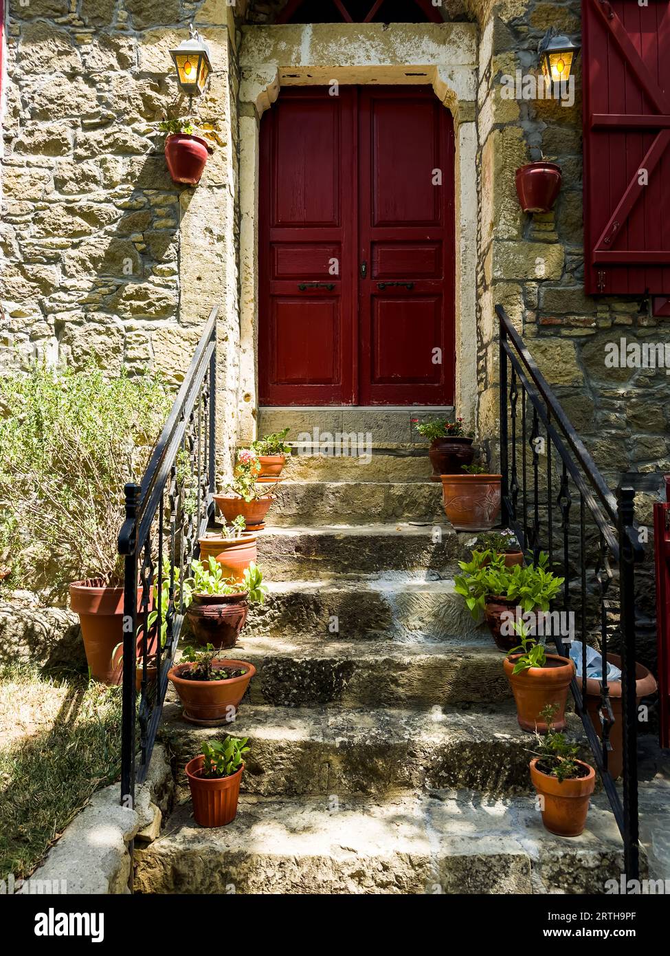 historical stone house with red doors and stone stairs decorated with