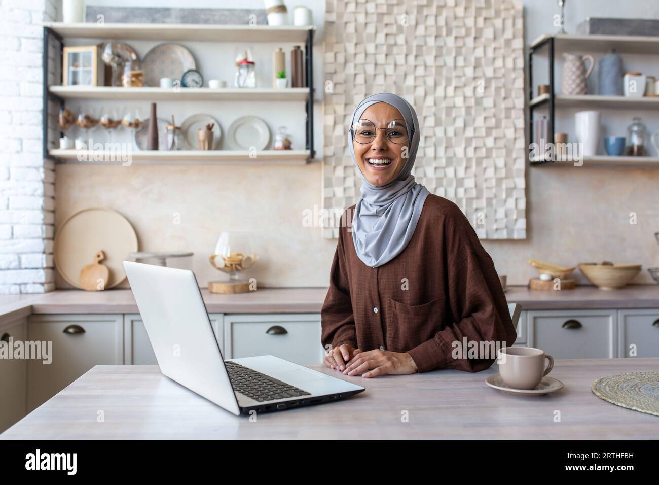 Portrait of young happy Muslim woman in hijab working and studying at ...