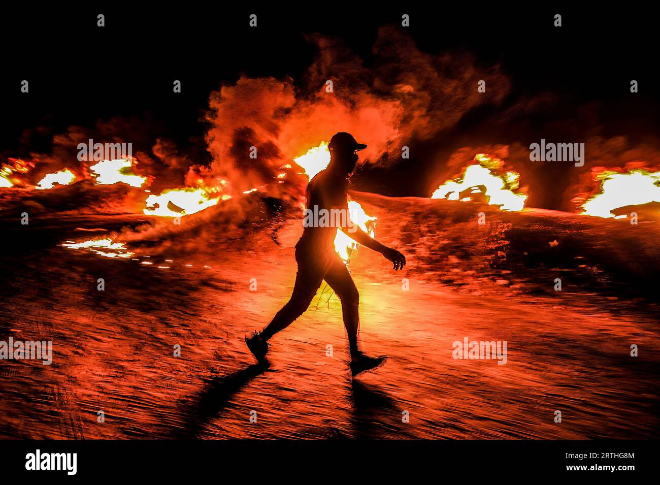 Gaza, Palestine. 12th Sep, 2023. Palestinian protesters burn tires during a night demonstration on the border between Gaza and Israel in solidarity with Palestinian prisoners in Israeli prisons. (Photo by © Yousef Masoud/SOPA Images/Sipa USA) Credit: Sipa USA/Alamy Live News Stock Photo