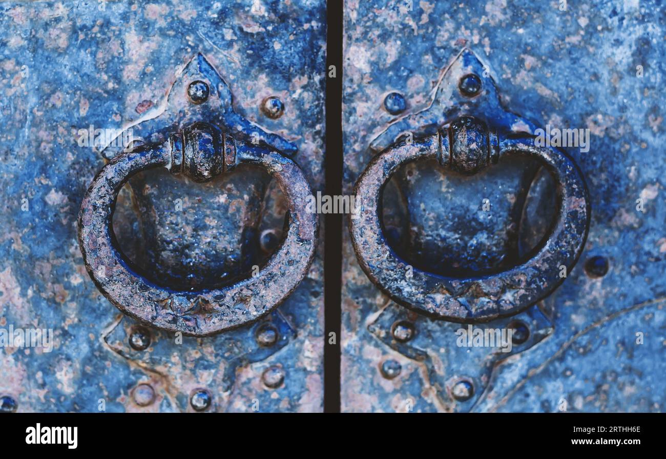 Bright blue iron door with round handles Stock Photo - Alamy