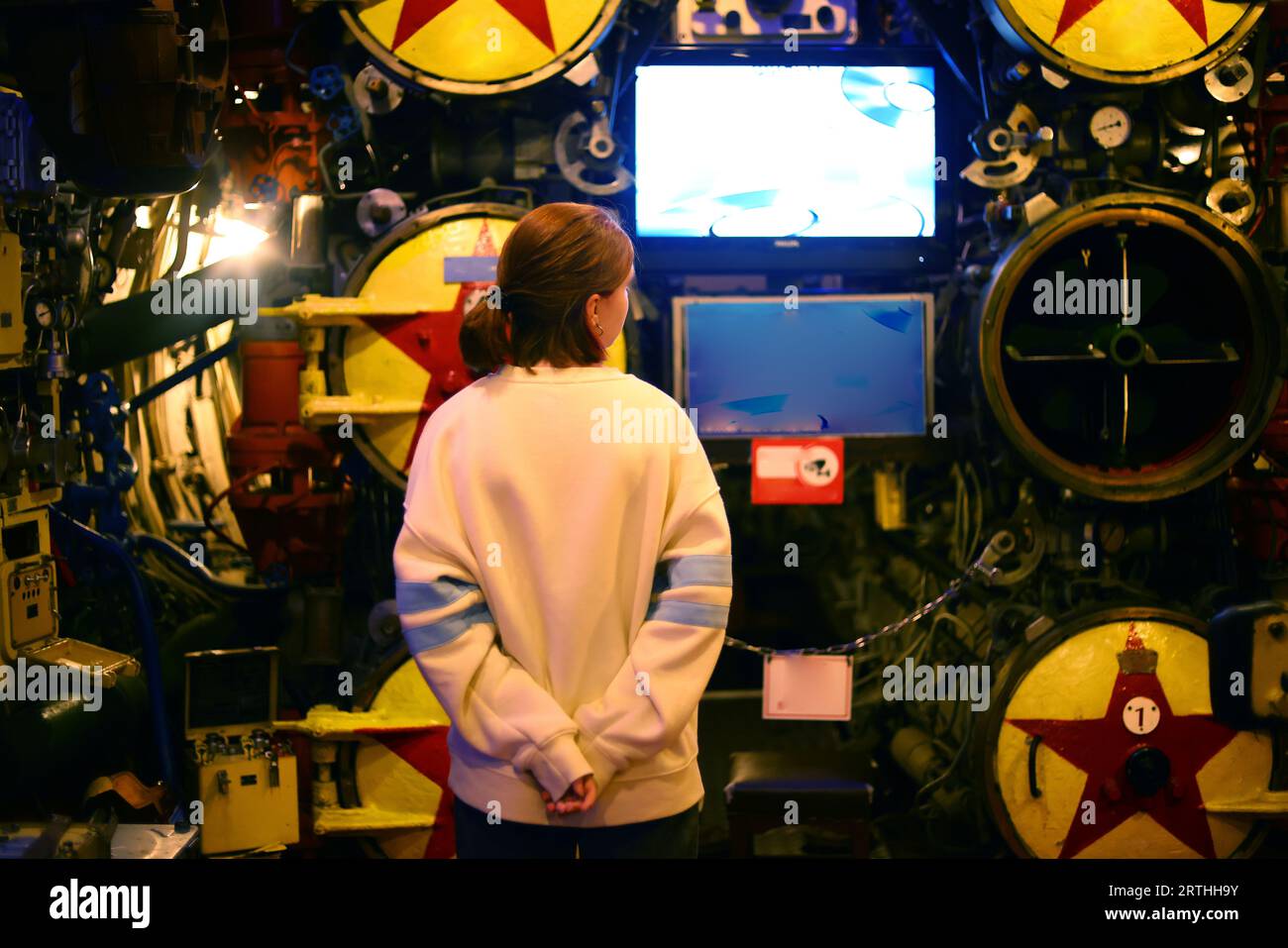 teenager studying the structure of a submarine Stock Photo