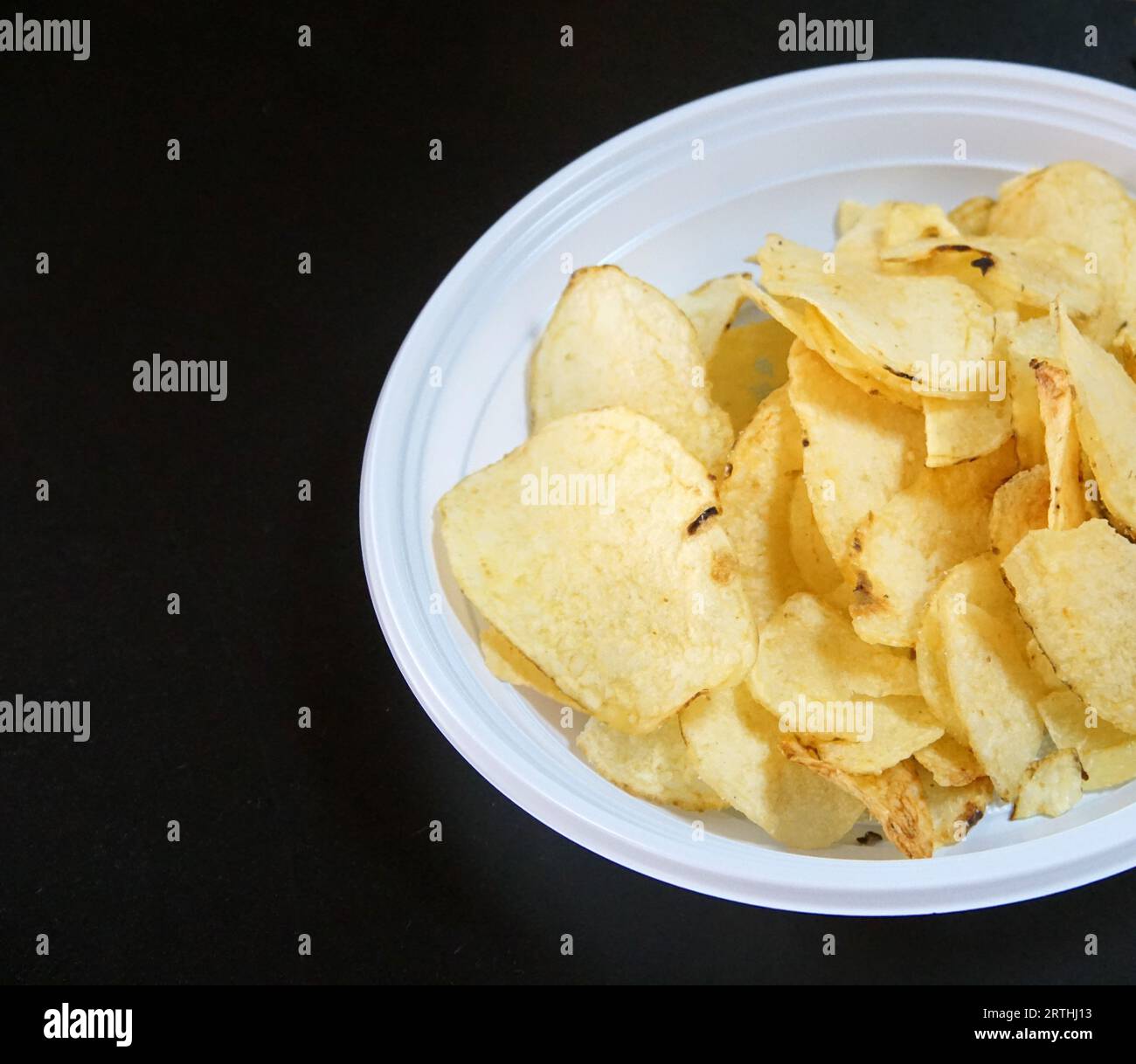 Crispy potato chips in a plastic disposable plate Stock Photo
