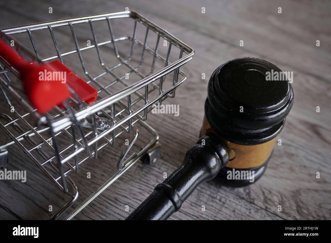 Closeup image of judge gavel and shopping trolley on table. Consumer rights, customer protection, commercial law concept Stock Photo