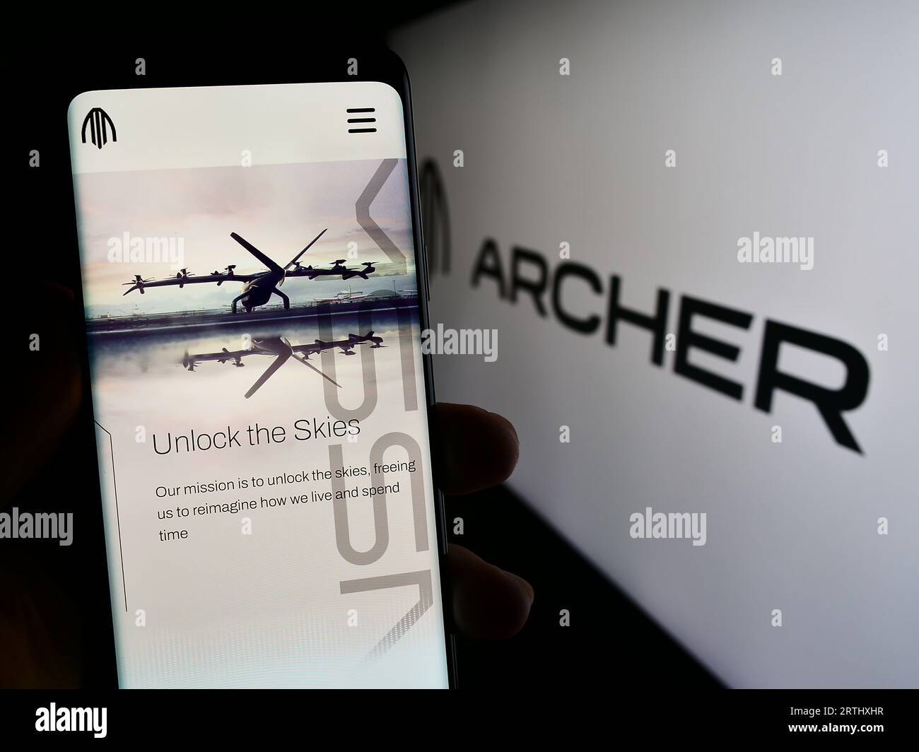Person holding mobile phone with web page of US eVTOL aircraft company Archer Aviation Inc. on screen with logo. Focus on center of phone display. Stock Photo