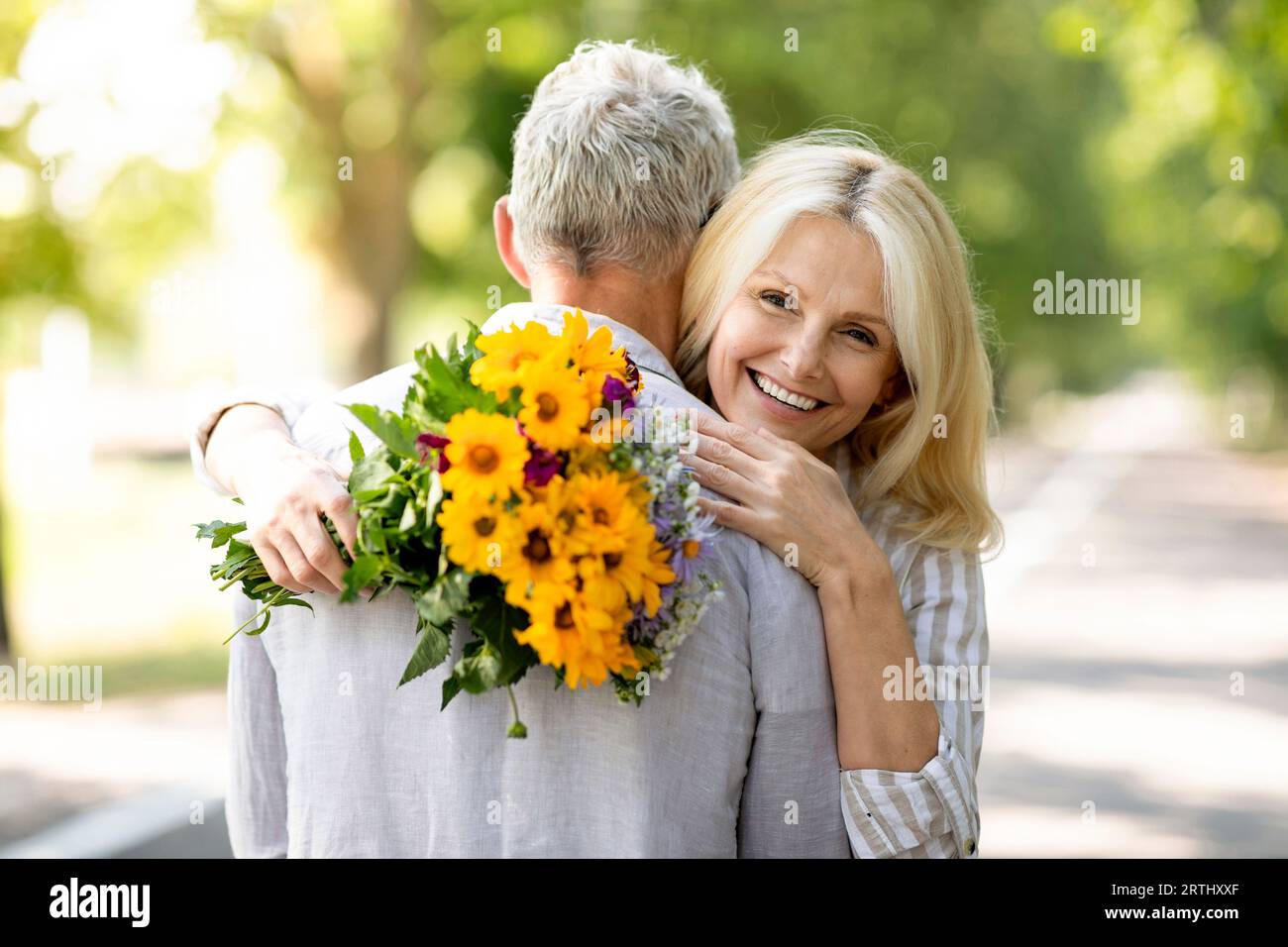 Happy older man giving flowers hi-res stock photography and images - Alamy