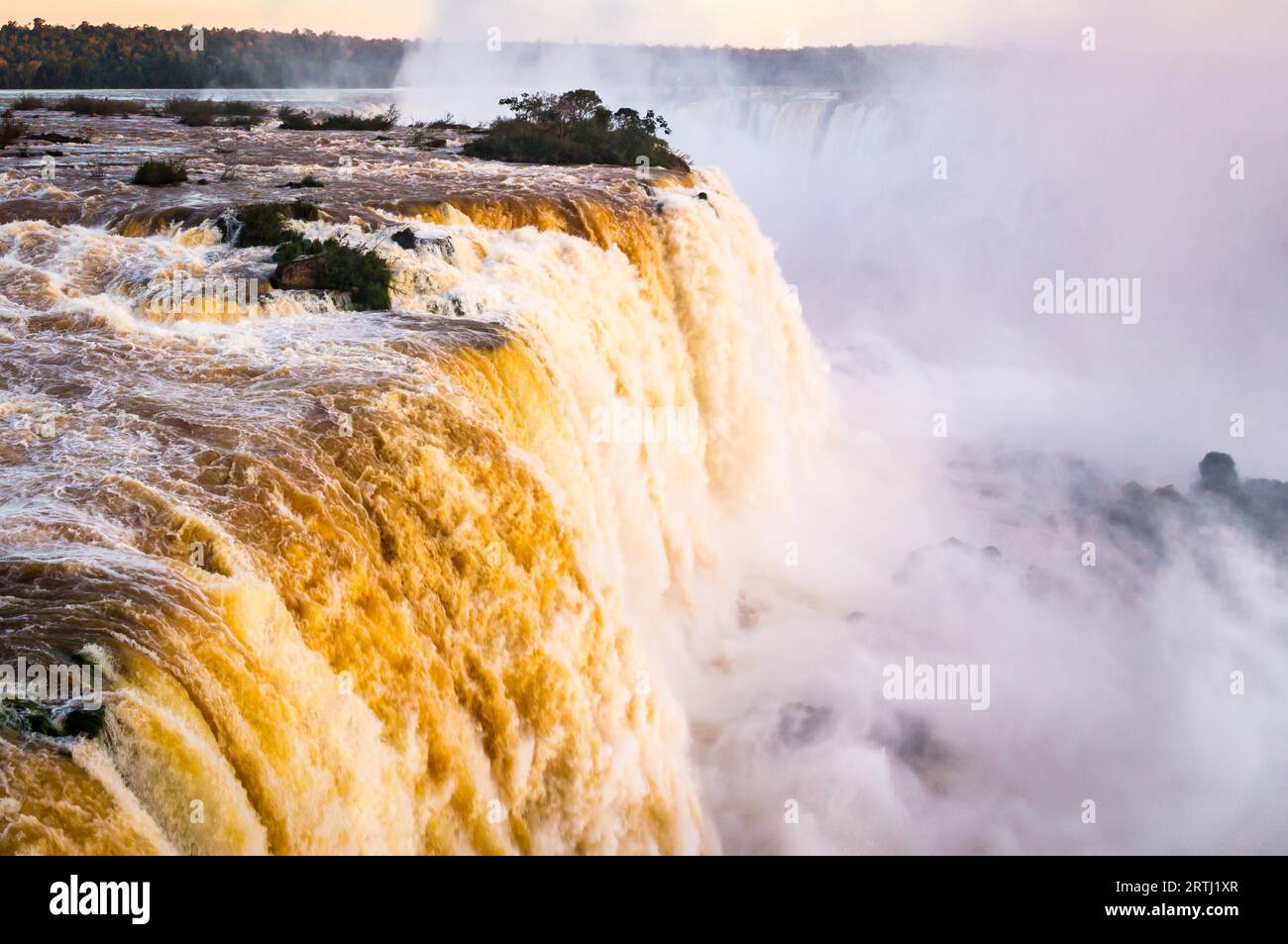 Beautiful Sunset Colors at Cataratas do Iguacu at Iguazu Falls, Foz do Iguacu, Parana State, Brazil. In the evening the Iguacu Falls in Brazil shine Stock Photo