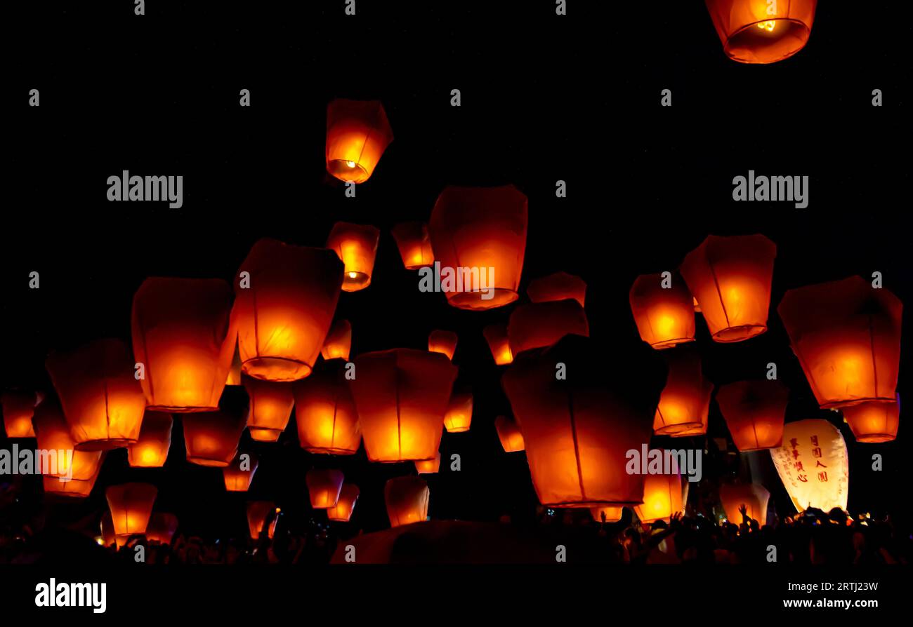 Glowing paper lanterns illuminate the night sky during the Pingxi sky lantern festival in Taiwan Stock Photo