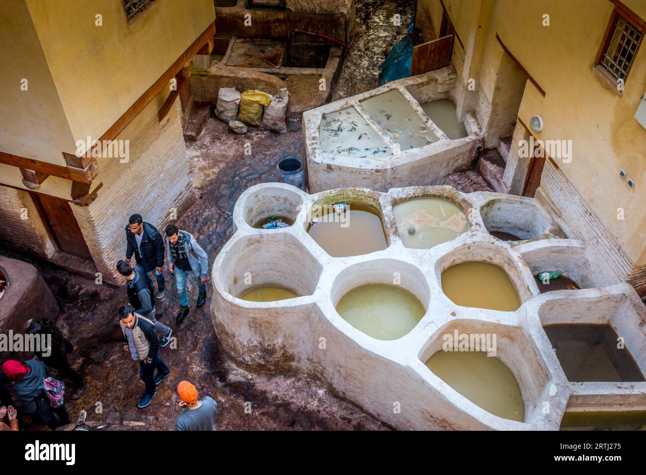 Fes, Morocco on February 22, 2018: A group of tourists walk along the stone vessels containing dyes, tanneries, Fez, Morocco Stock Photo