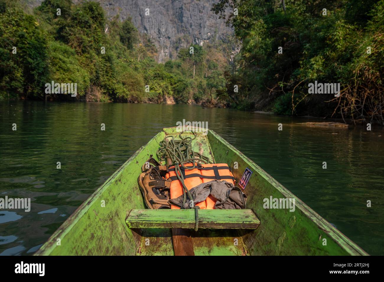 Wooden boat with brown and orange life vests, Konglor Cave, Thakhek, Laos Stock Photo