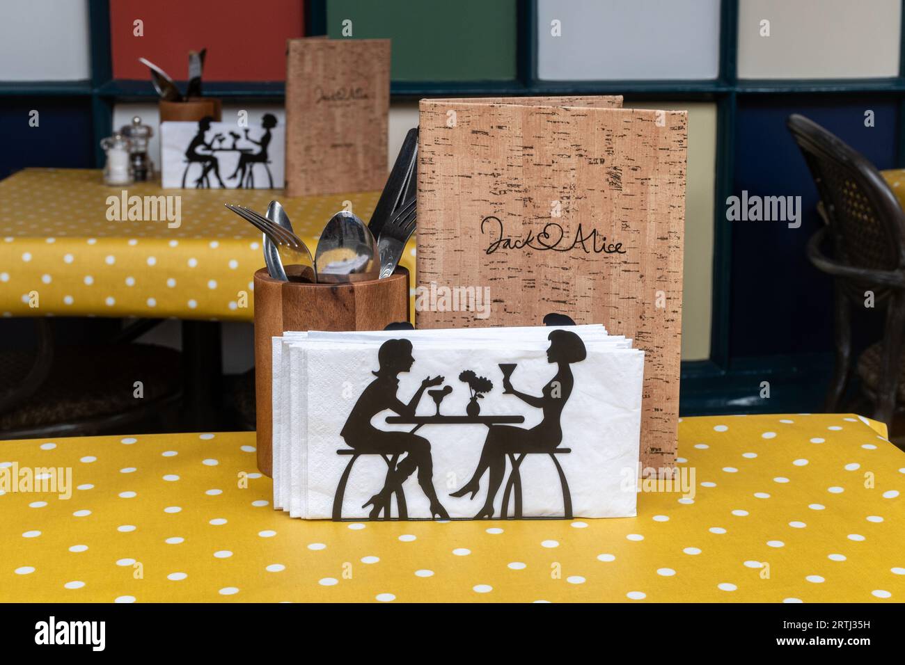 Tables set outside a restaurant with unusual napkin holders, cutlery and menu, England, UK Stock Photo