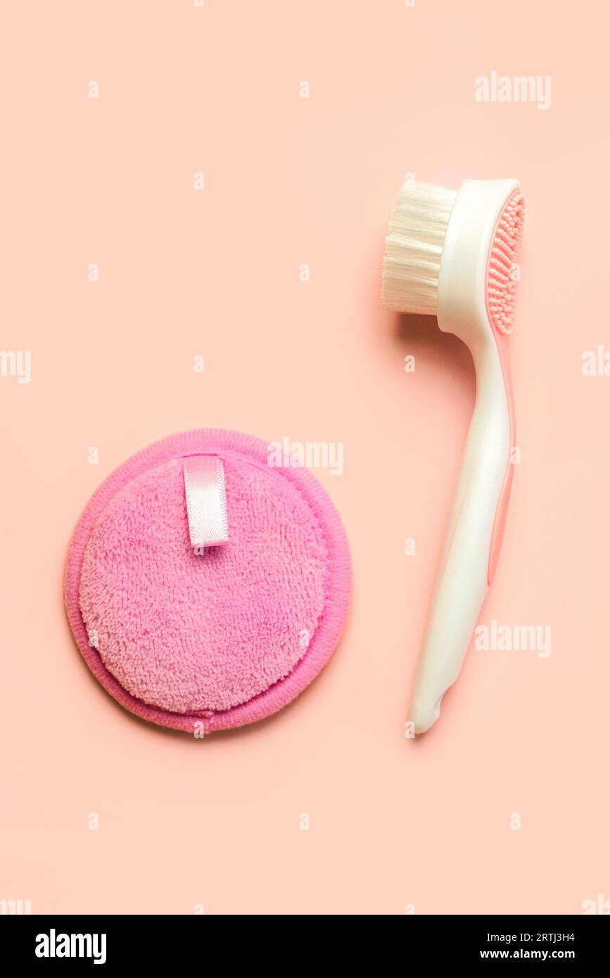 Facial cleansing brush and reusable cotton makeup remover pad over pink background. Facial cleansing concept Stock Photo