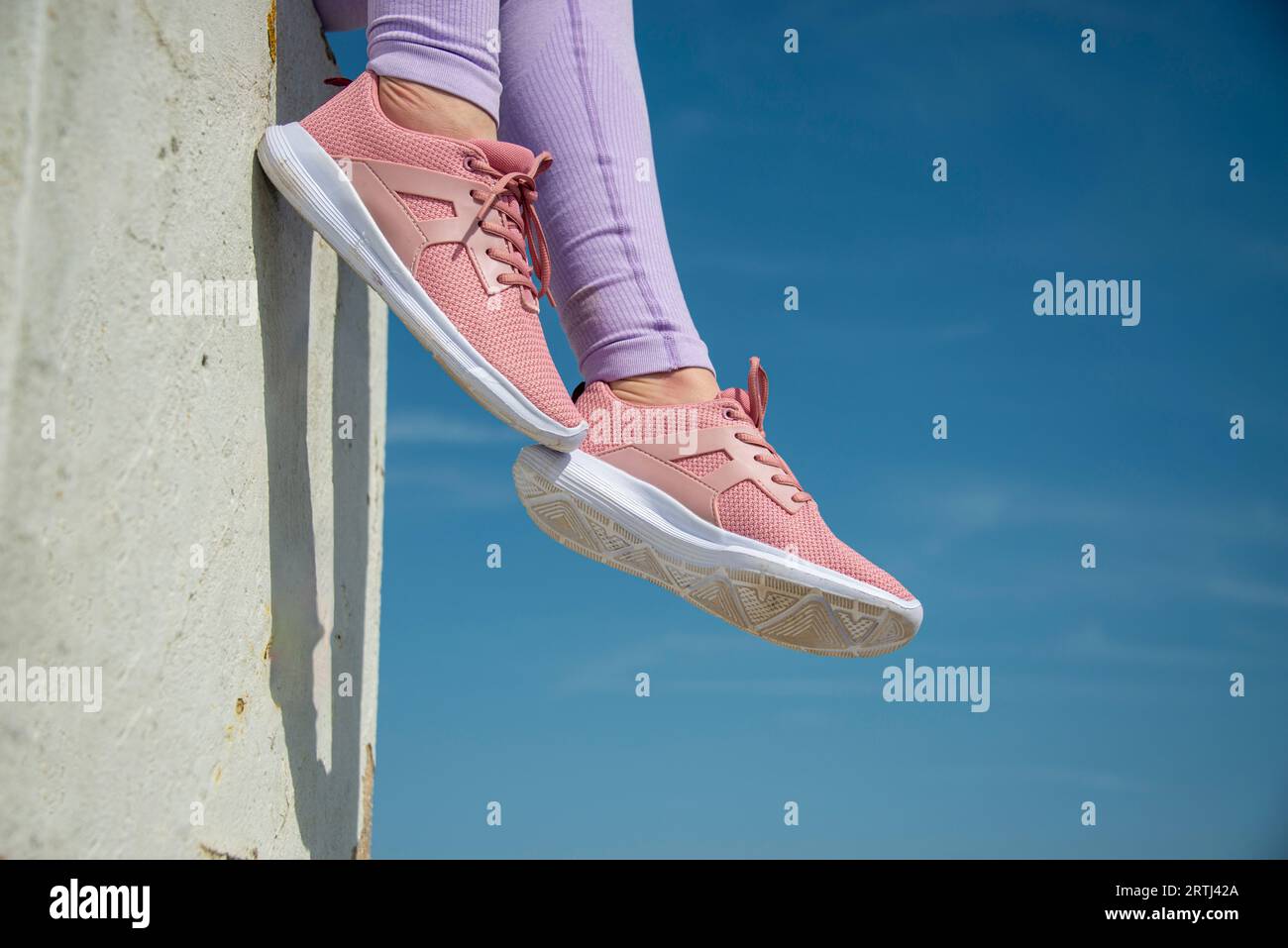 close up of pink trainers against a blue sky background, fitness concept Stock Photo