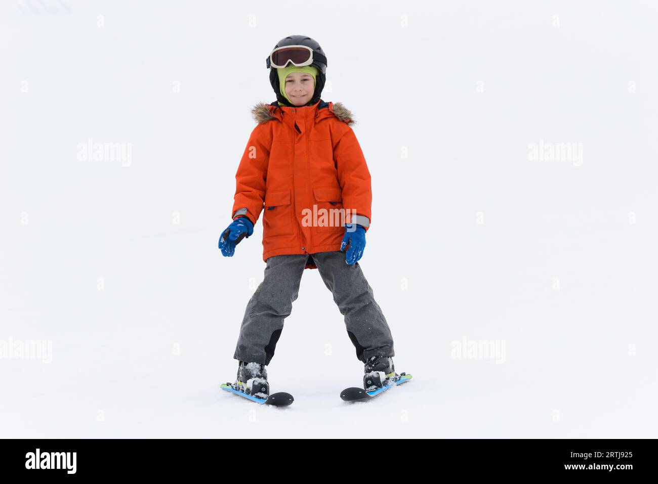 Kid boy on mountain ski against white snow background Stock Photo
