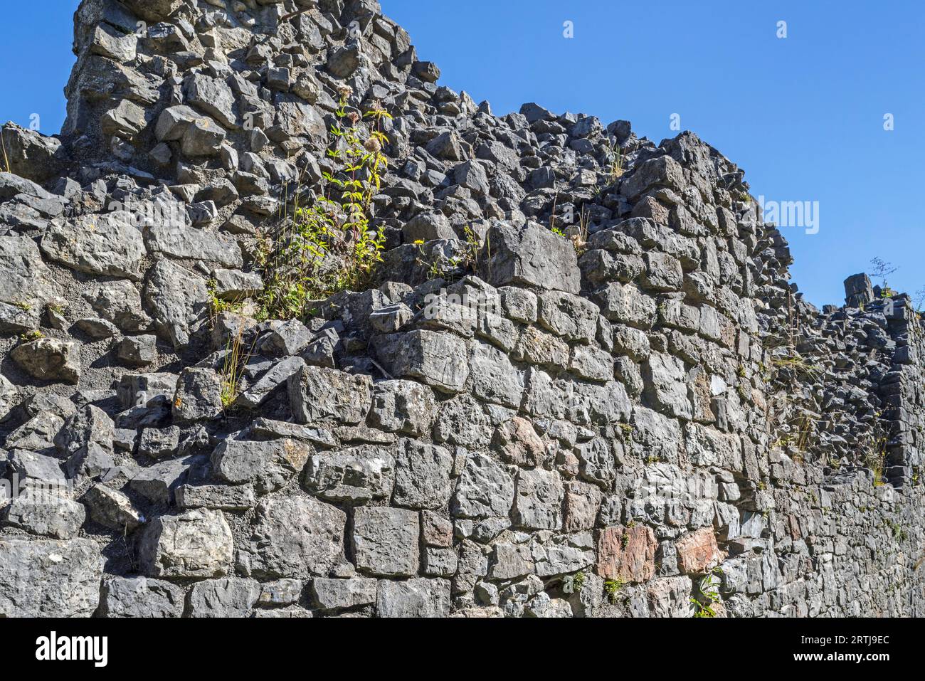 Thick stone wall of medieval castle showing two types of masonry