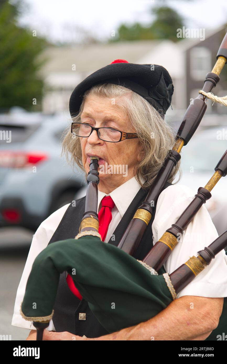 911 commemoration ceremony at Barnstable, MA Fire Headquarters on Cape Cod, USA. A woman bagpiper at the event Stock Photo