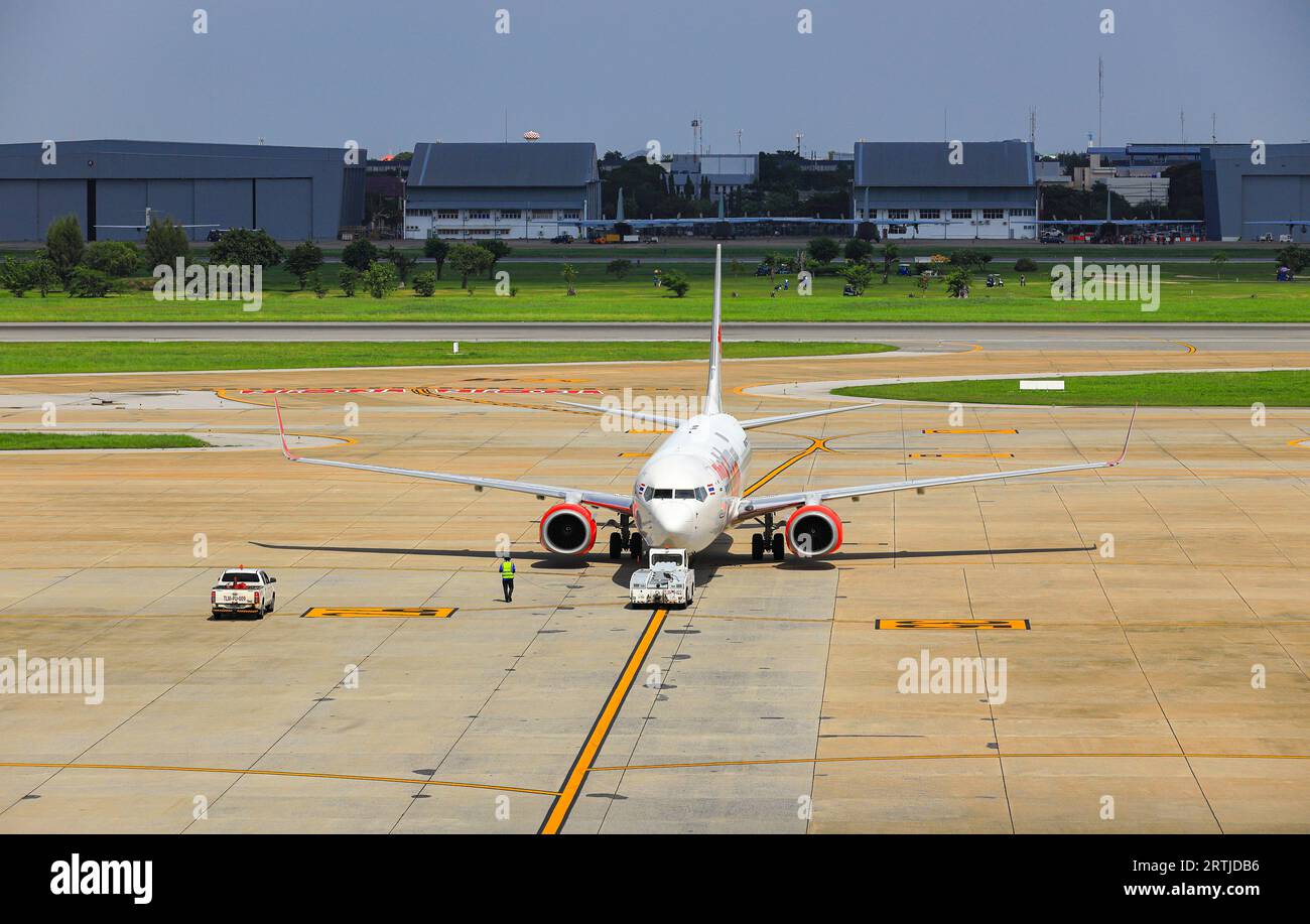 Aircraft push back by airplane Tugs to taxiway, one in ground handling services. Stock Photo
