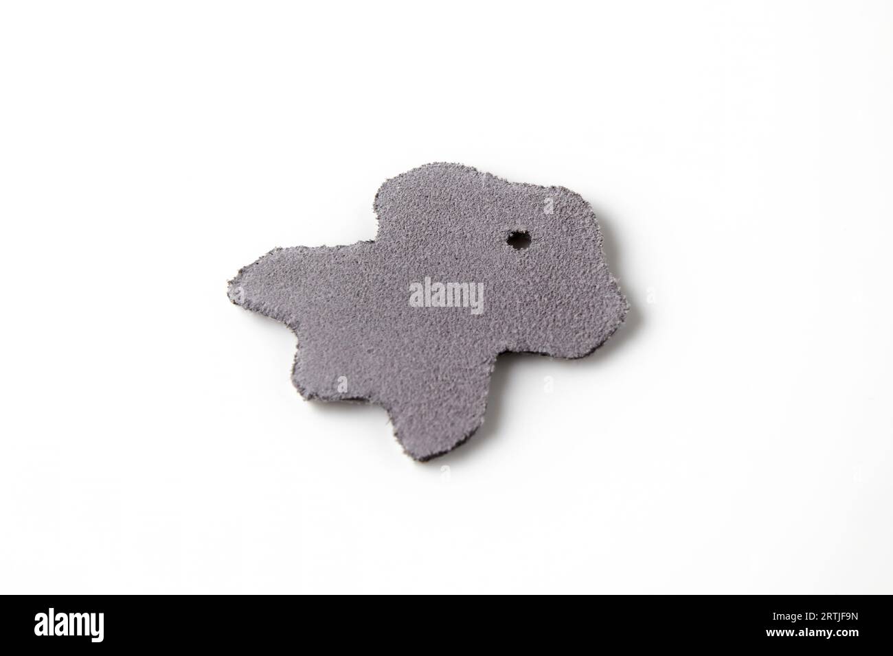 A piece of split leather and nubuck in the shape of a symbol of genuine