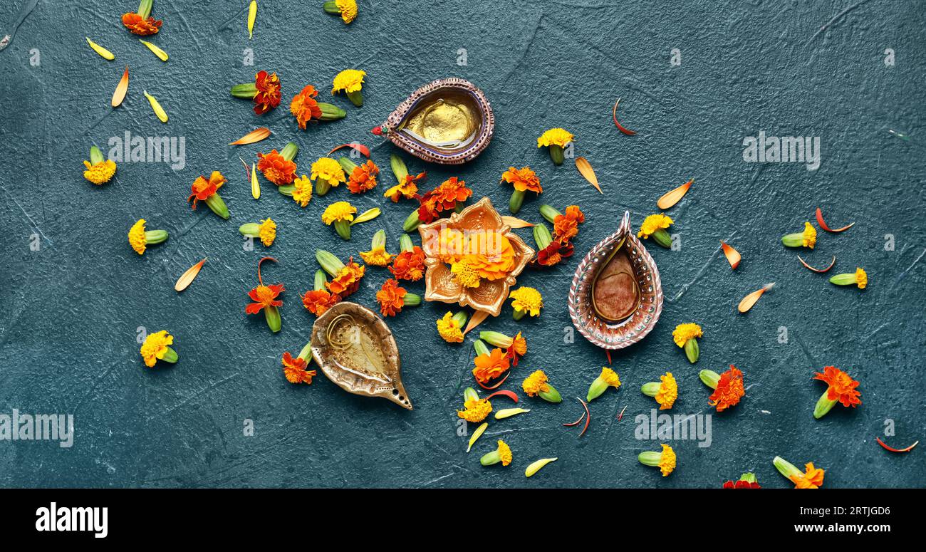 Diya lamps with marigold flowers on dark background. Divaly celebration Stock Photo