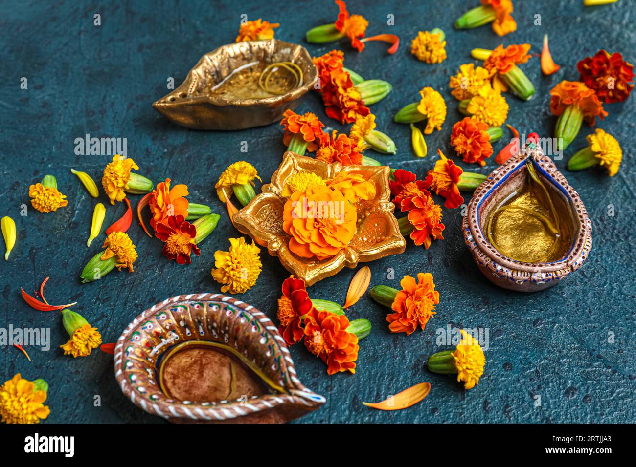 Diya lamps with marigold flowers on grunge blue background. Divaly celebration Stock Photo