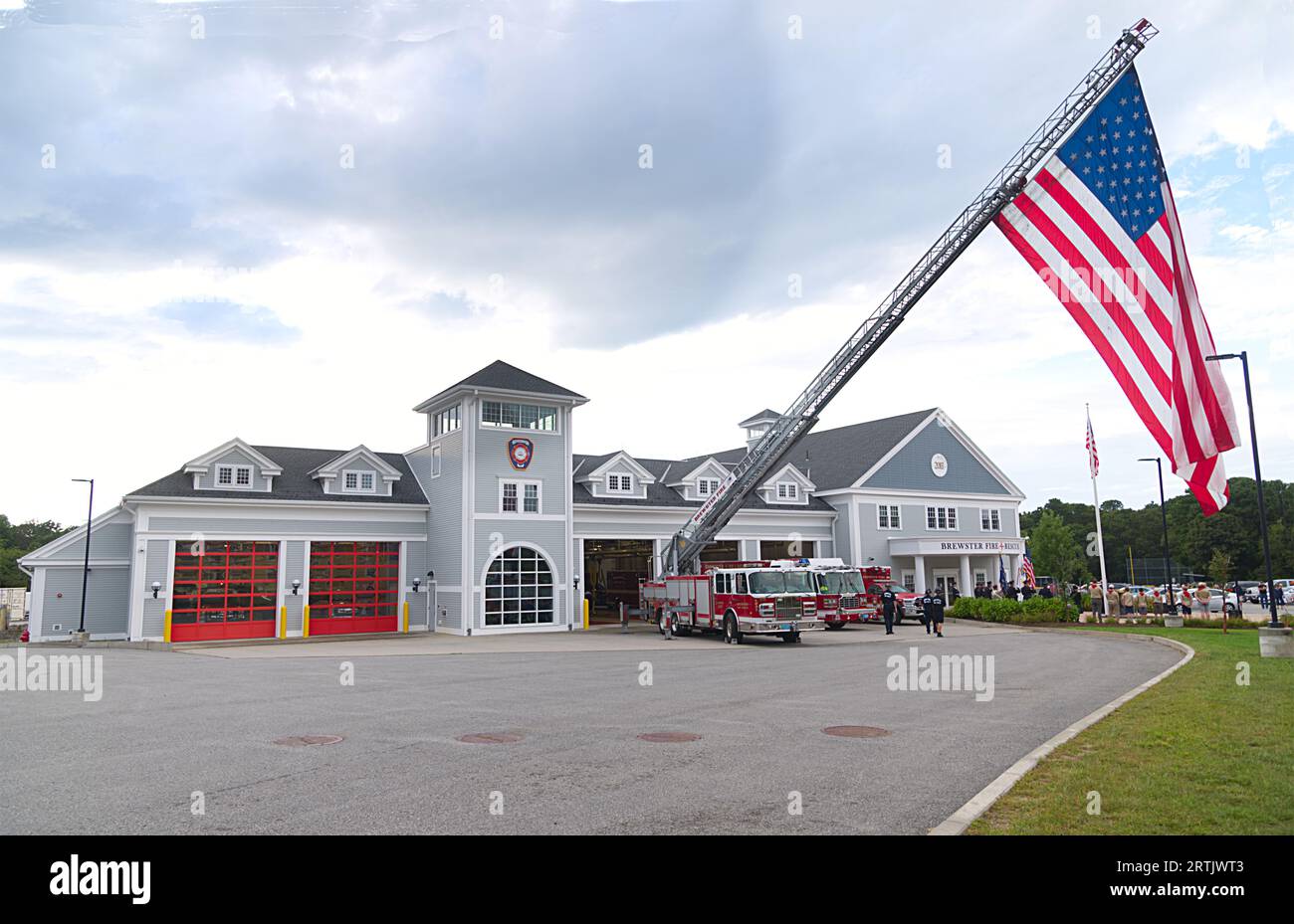 911 commemoration ceremony at Brewster, MA Fire Headquarters on Cape Cod, USA.   Brewster Fire Headquarters with large American Flag on display. Stock Photo