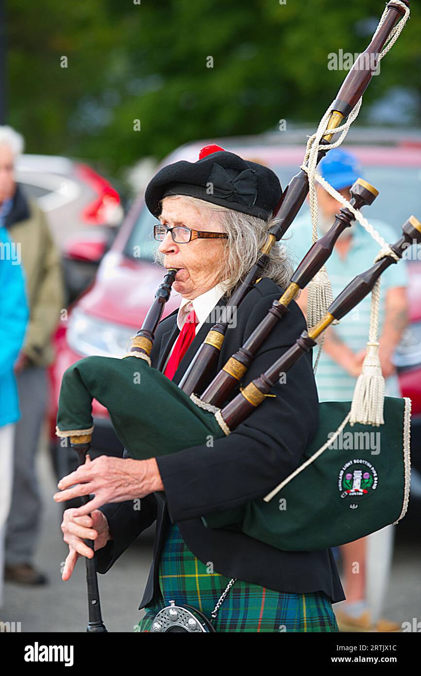 911 commemoration ceremony at Brewster, MA Fire Headquarters on Cape Cod, USA. A bagpiper parades through the crowd. Stock Photo