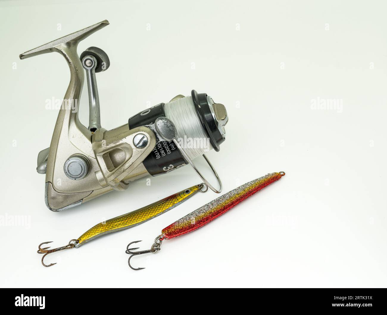fishing wheel with two golden lures isolated on white Stock Photo Alamy
