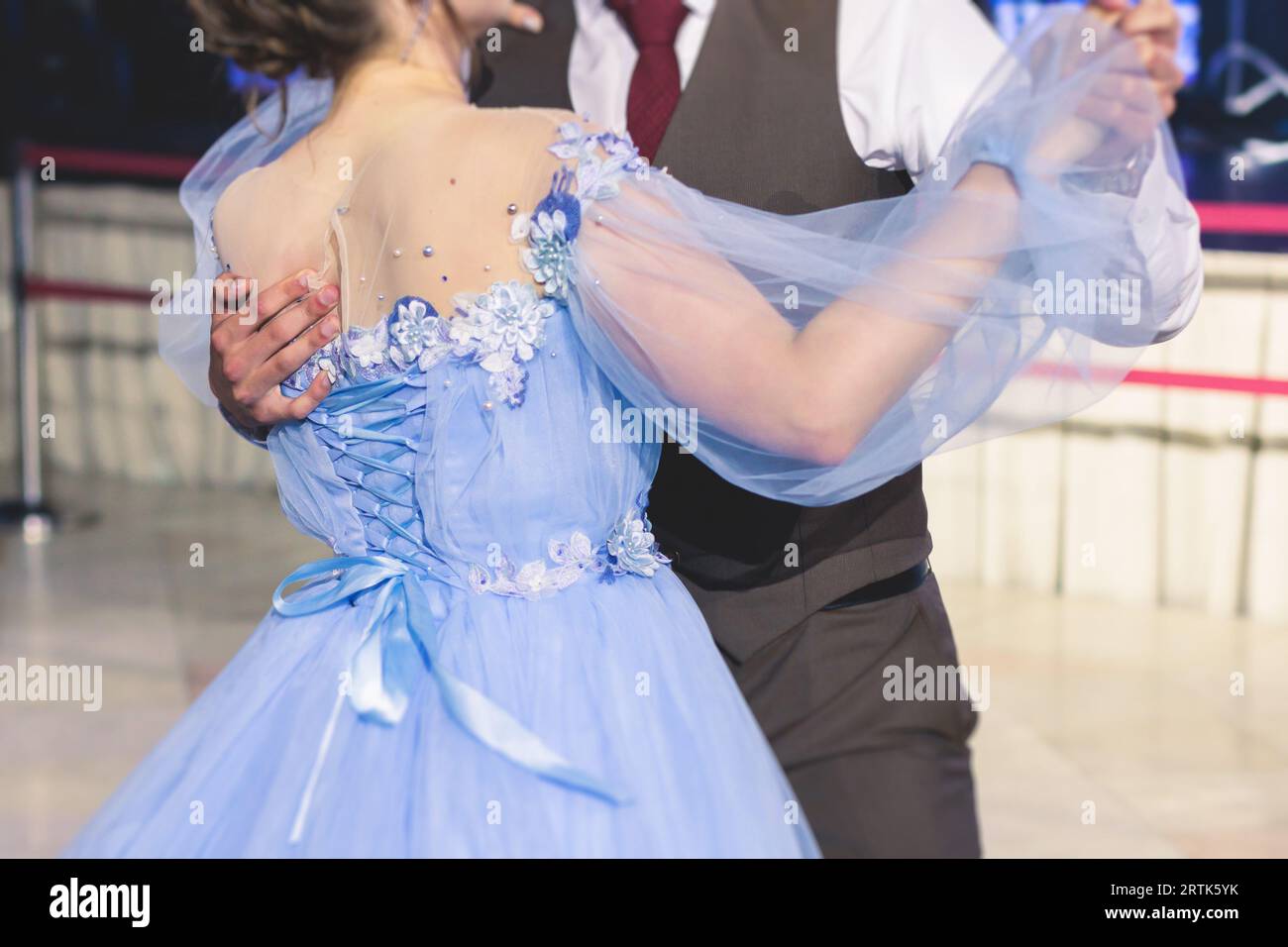 High school graduates dancing waltz and classical ball dance in dresses