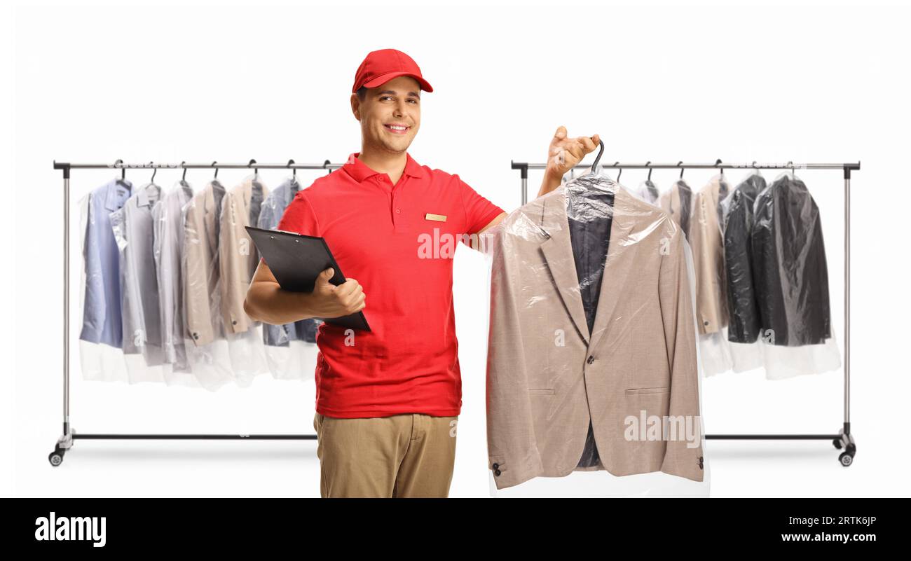 Dry cleaning worker holding a suit and a clipboard in front of clothing racks isolated on a white background Stock Photo
