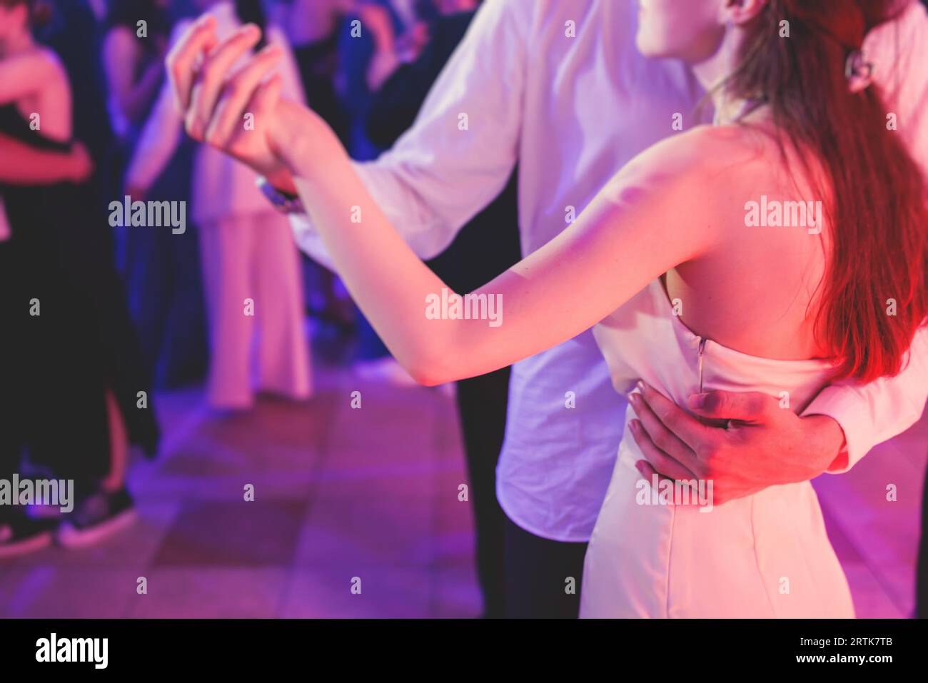 High school graduates dancing waltz and classical ball dance in dresses