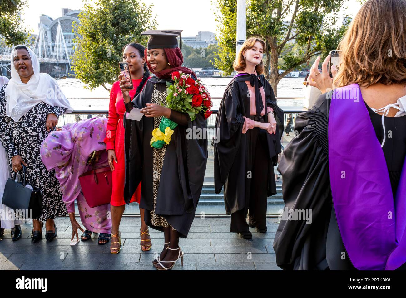 Degree Students Pose For Photos At Their Graduation Ceremony, The Southbank, London, UK. Stock Photo