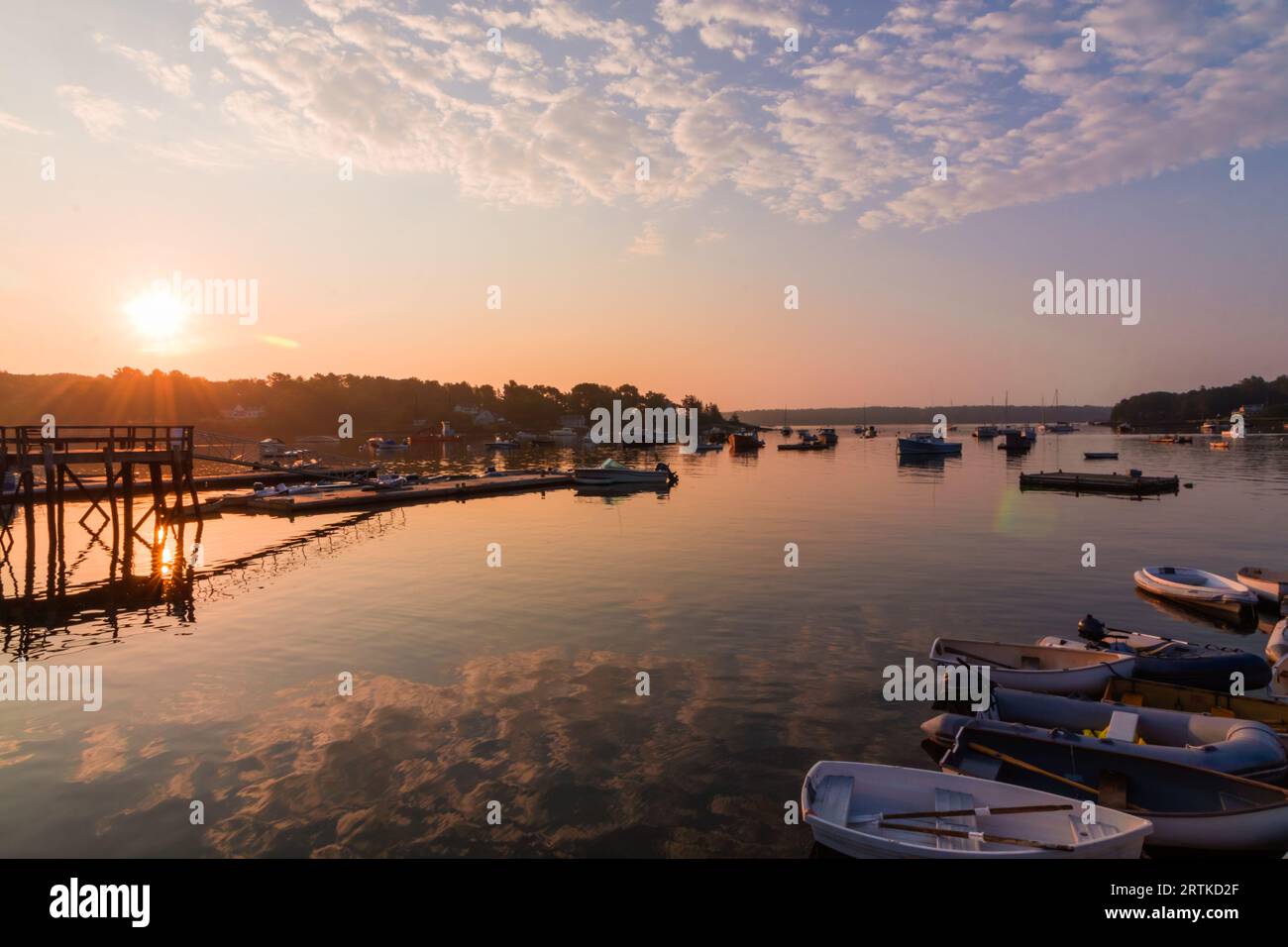 Boats in the quiet still morning at sunrise in summer with Muscongus Bay Lobster Co in background Stock Photo