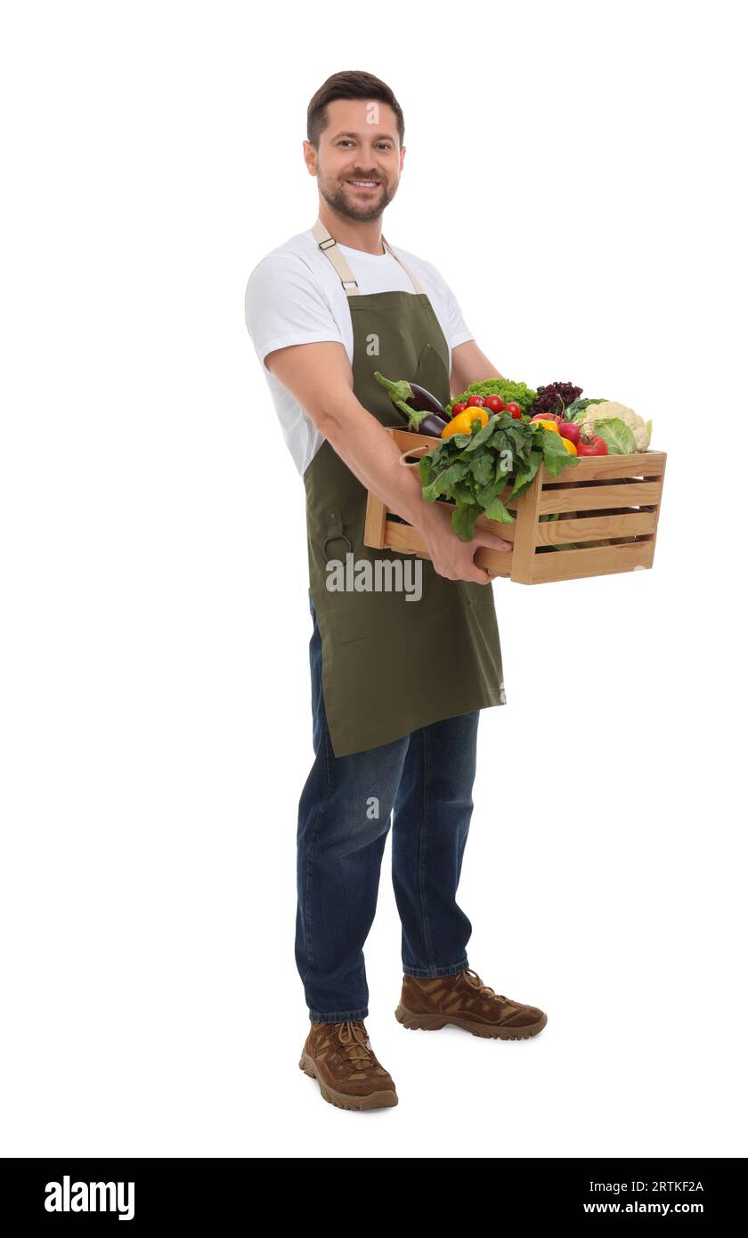 Harvesting season. Happy farmer holding wooden crate with vegetables on ...
