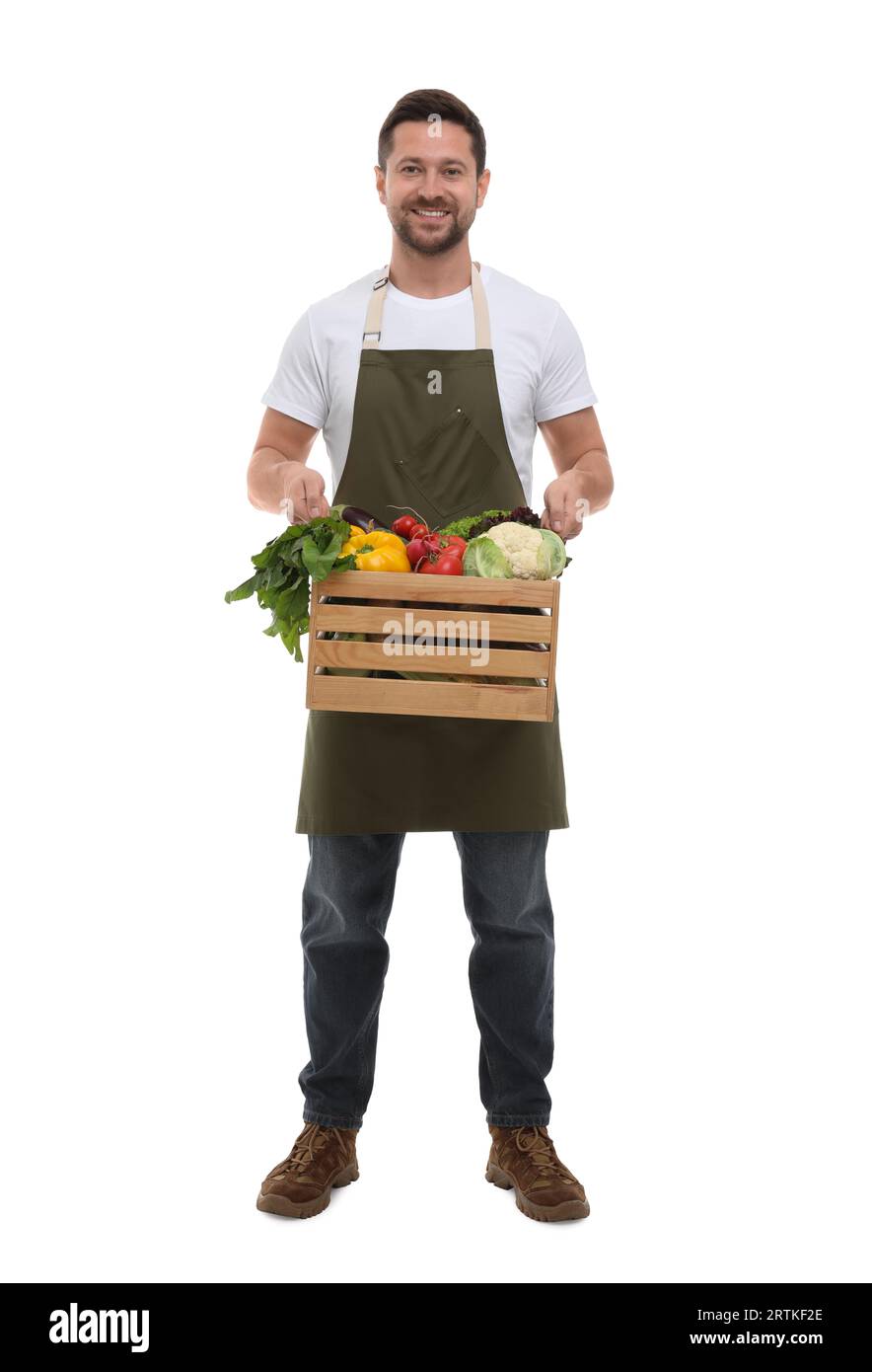 Harvesting season. Happy farmer holding wooden crate with vegetables on ...