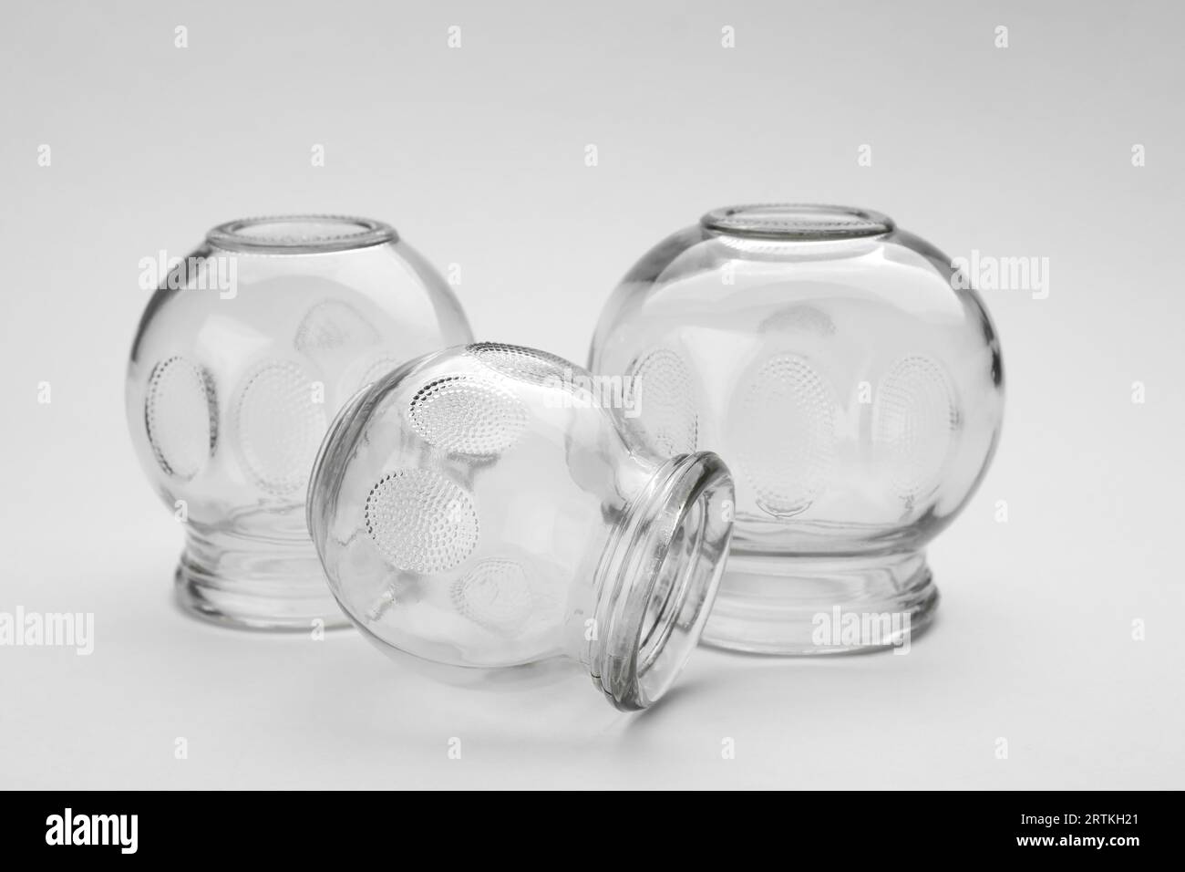 Glass cups on light grey background, closeup. Cupping therapy Stock