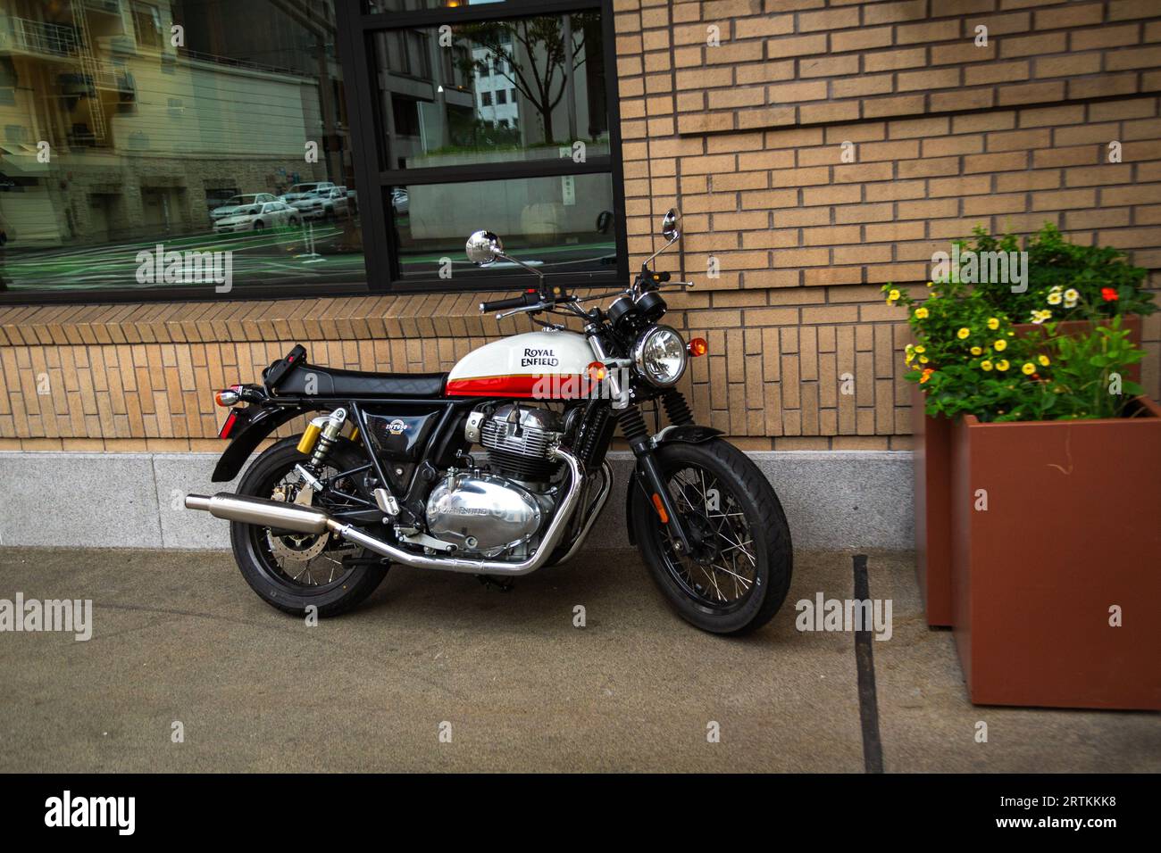 Royal Enfield motorcycle parked in front of a hotel in downtown Portland Oregon Stock Photo