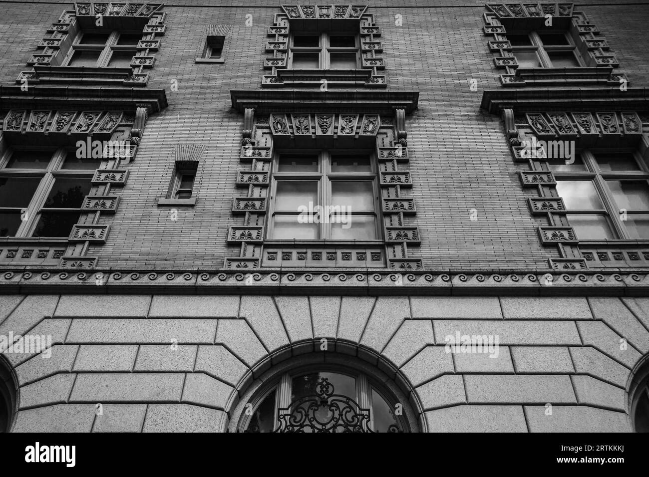 Black and white photo of symmetrical windows and brick work on the side of a building in downtown Portland Oregon Stock Photo