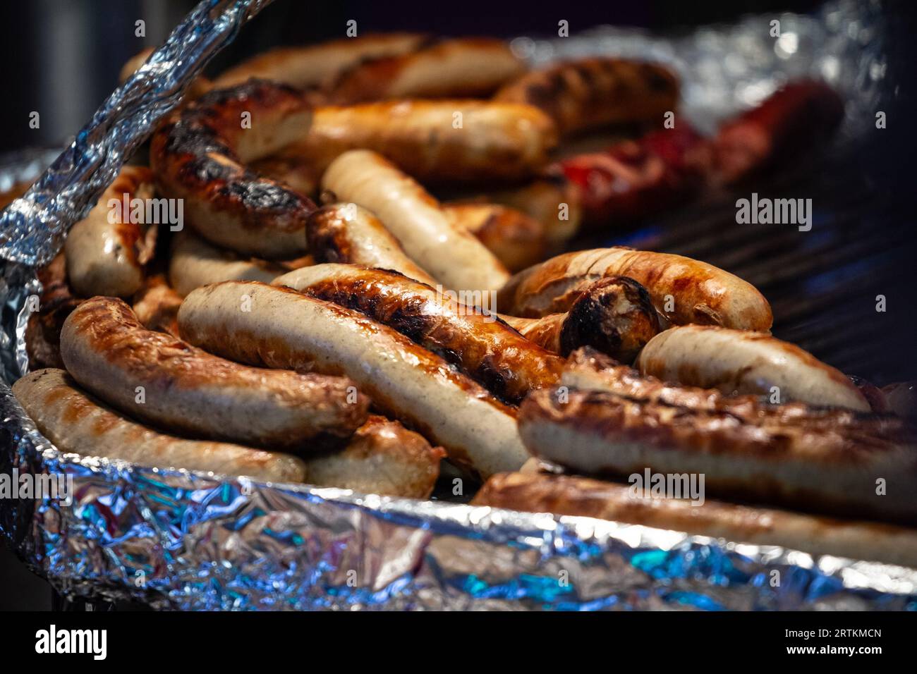 Picture of a batch of bratwurst sausages cooking in a fast food in
