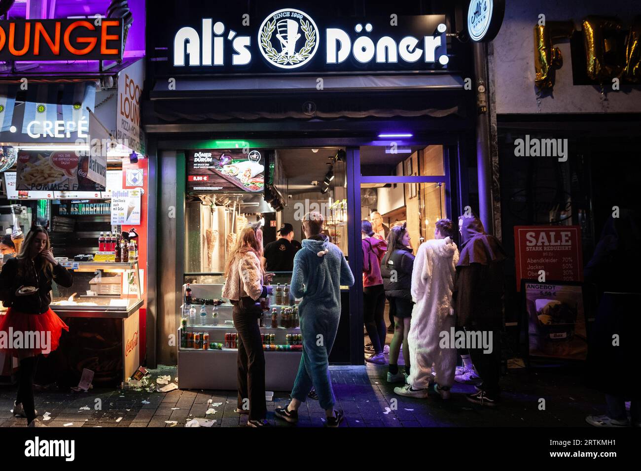 Picture of a street of Cologne, Germany at night, with a Kebab Fast Food restaurant lit. it is typical from the snacks and junk food in Europe, offeri Stock Photo
