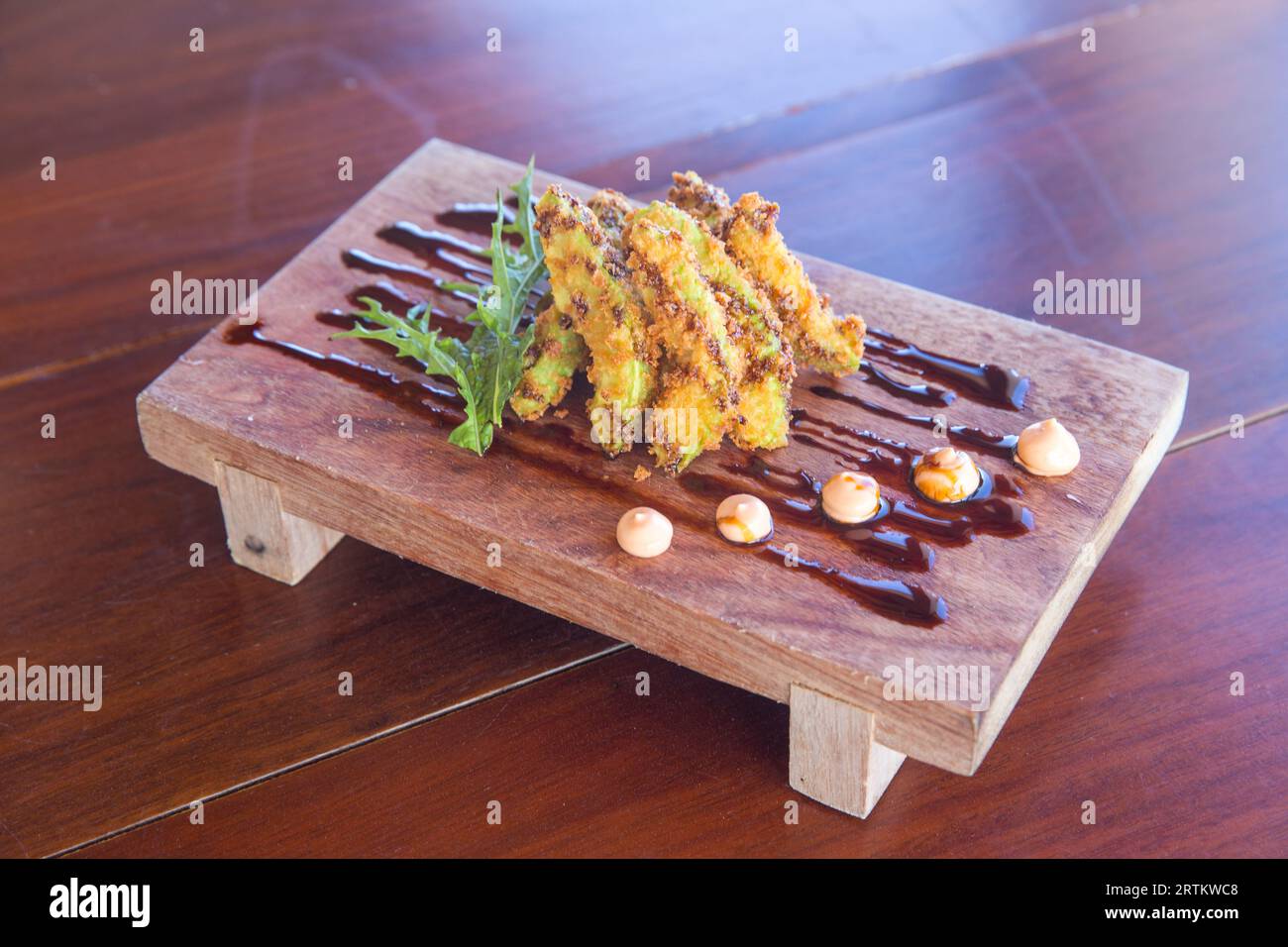 Deep fried avocado fries served with drizzlings Stock Photo Alamy