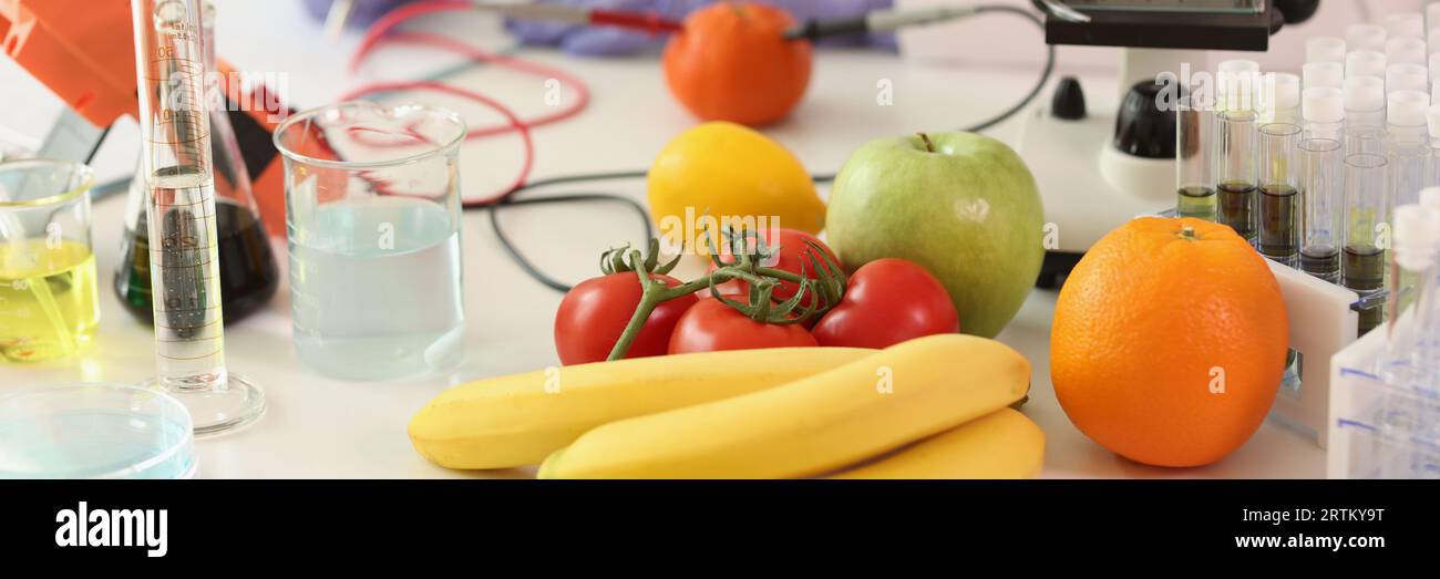 Fruits and vegetables with scientific equipment in laboratory ...