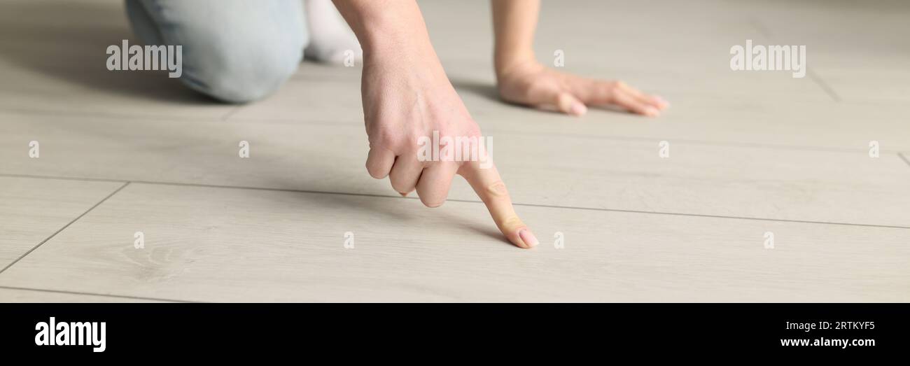 Close-up of woman pointing at wooden floor with her index finger Stock ...