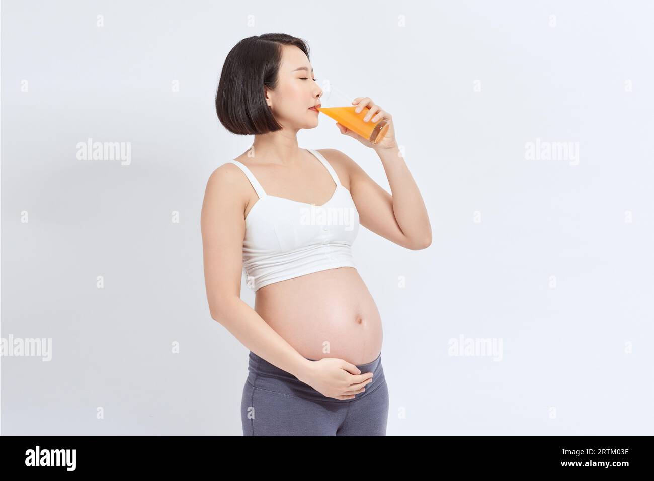 pregnant woman drinking orange juice isolated on white background Stock ...