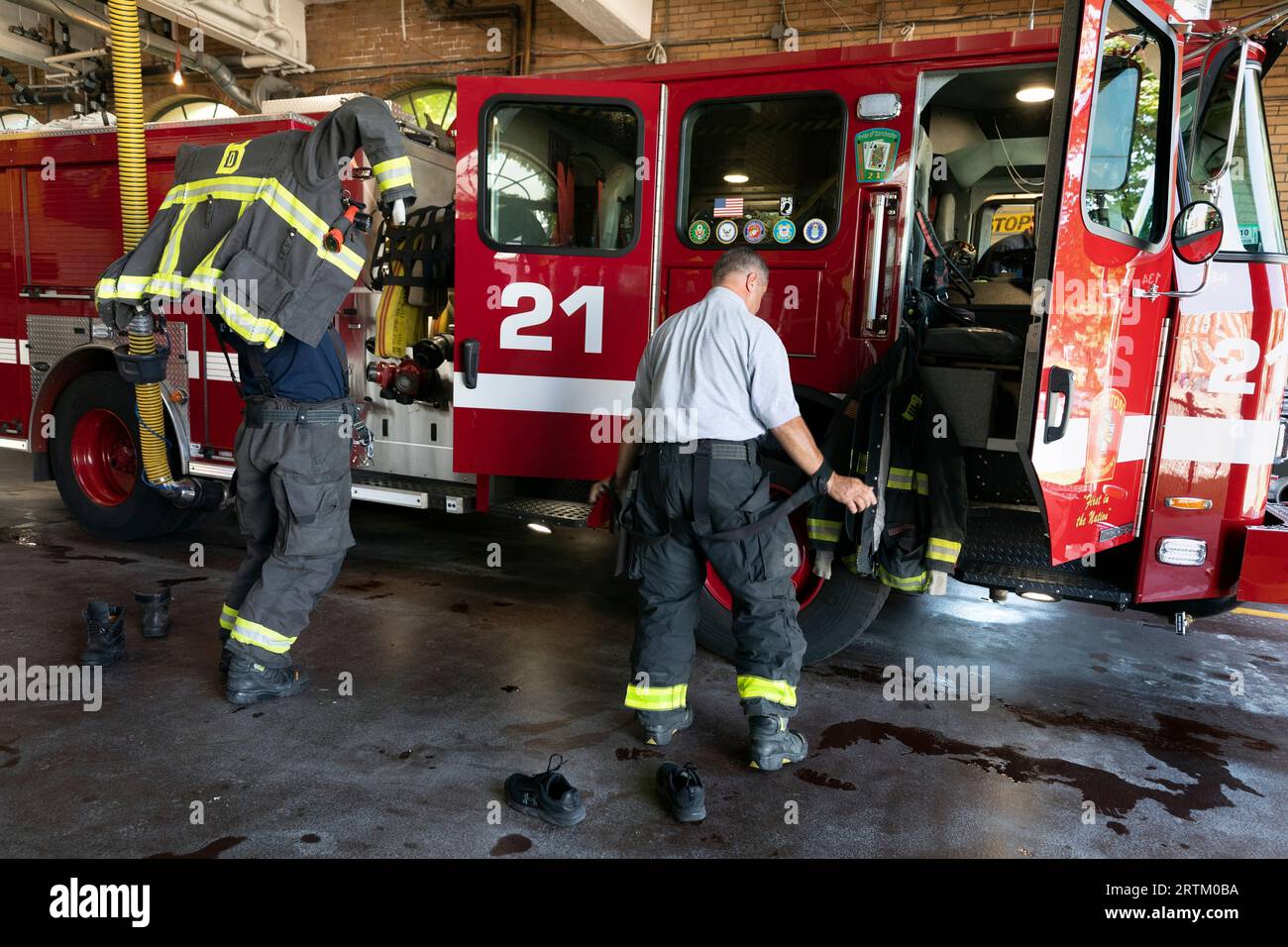Firefighter Rod MacKinnon, left, and Lt. Chris Stevens don their