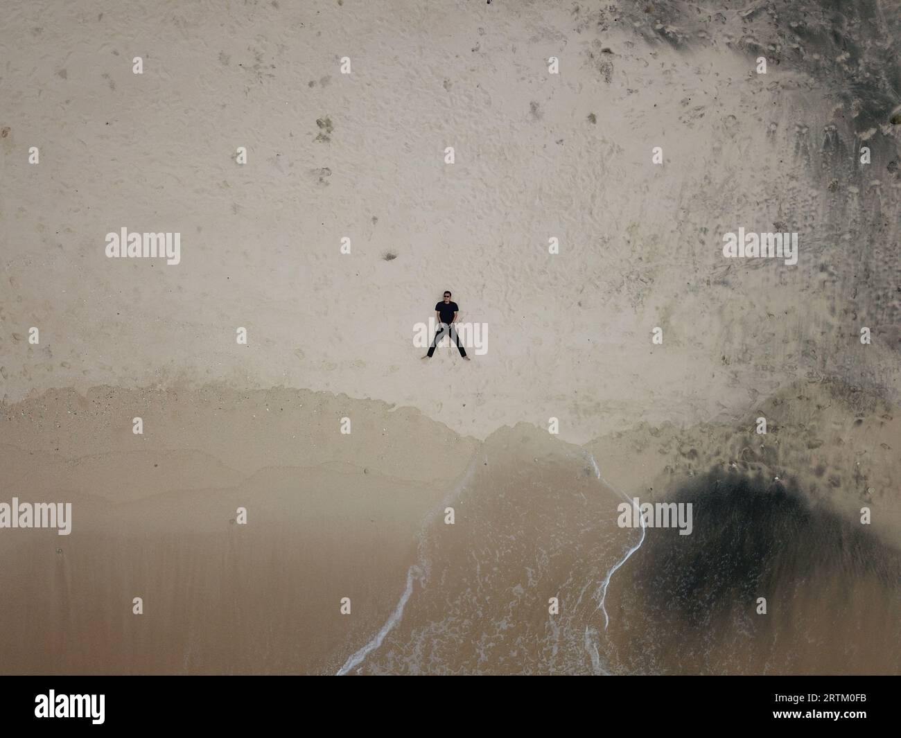 aerial view, a man lying on the shoreline and flying a drone Stock ...