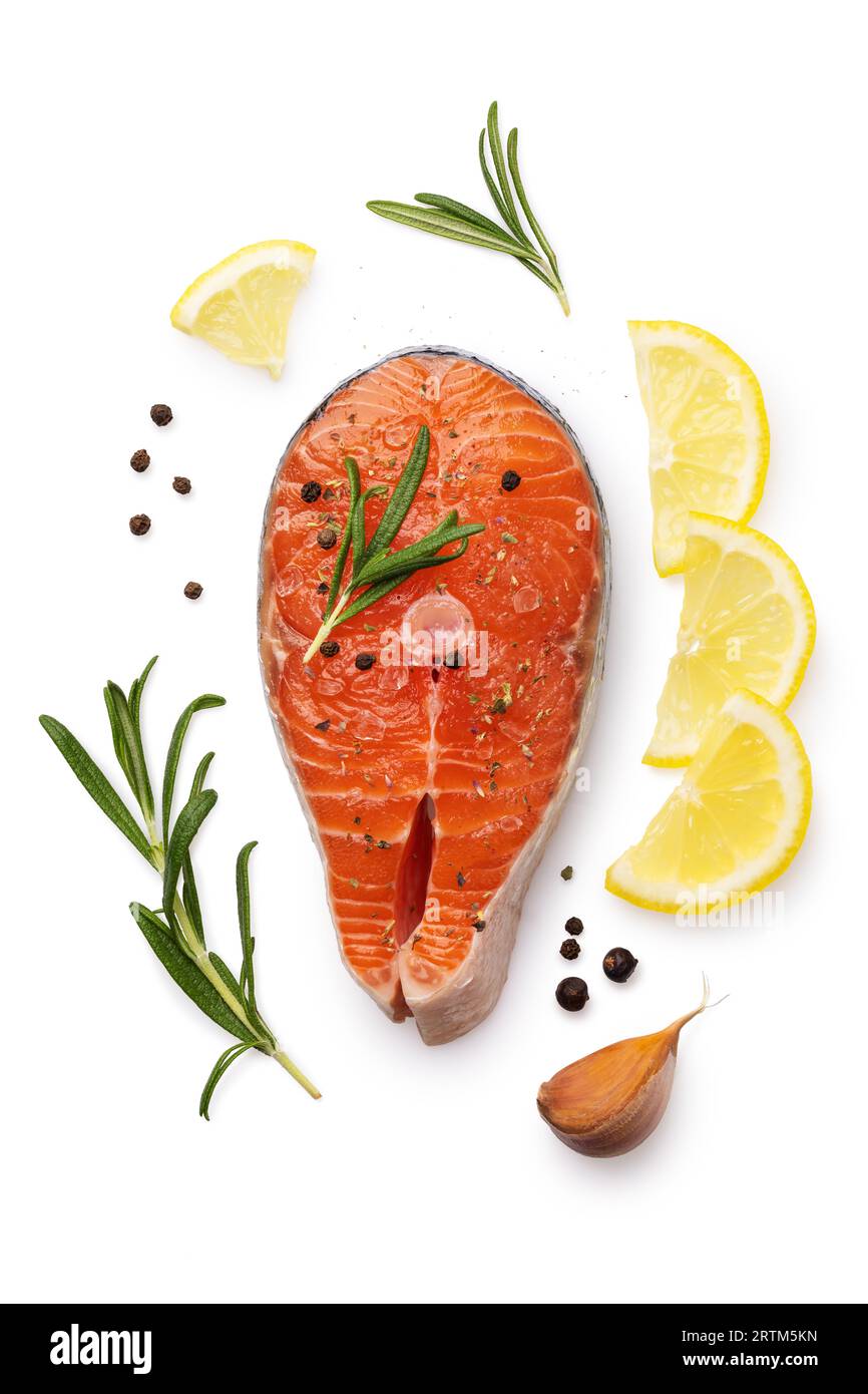 One fresh raw salmon steak surrounded by ingredients, top view of a piece of red fish isolated on a white background Stock Photo