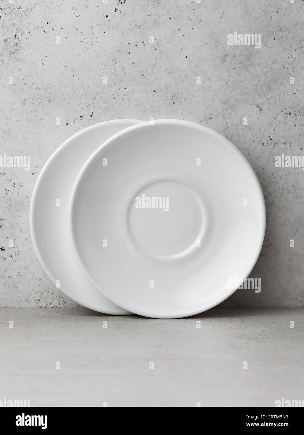 Two white ceramic saucers on the table Stock Photo