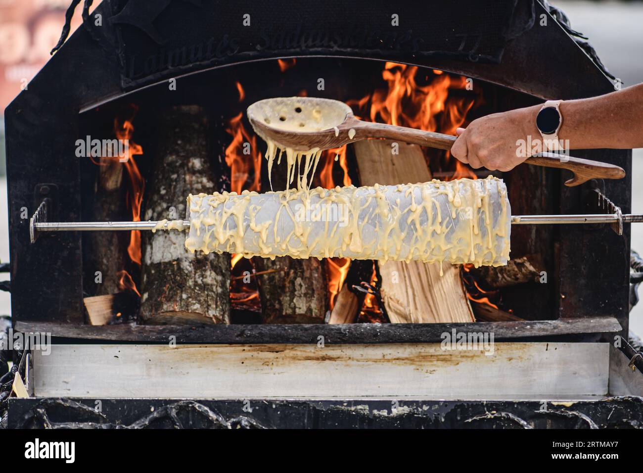 Initial stage of preparation of a tree cake, Lithuanian šakotis, Polish sękacz, Belarusian bankucha, German baumkuchen cooked over an open fire Stock Photo