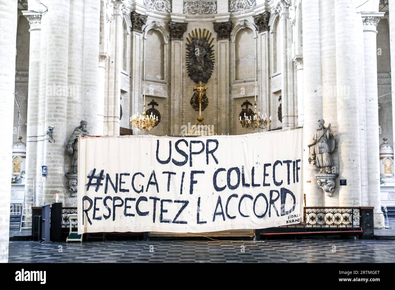 Banner in Beguinage catholic church, Brussels, Belgium. Union des sans-papier pour la Regularisation Stock Photo